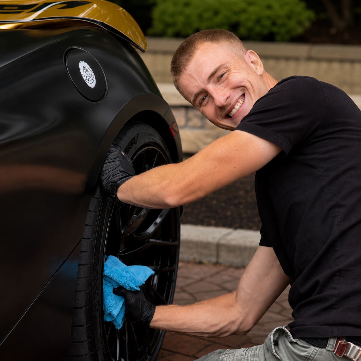 Charles Liggett of Liggett Mobile Detailing hand-detailing a wheel on a black sports car in Vancouver BC