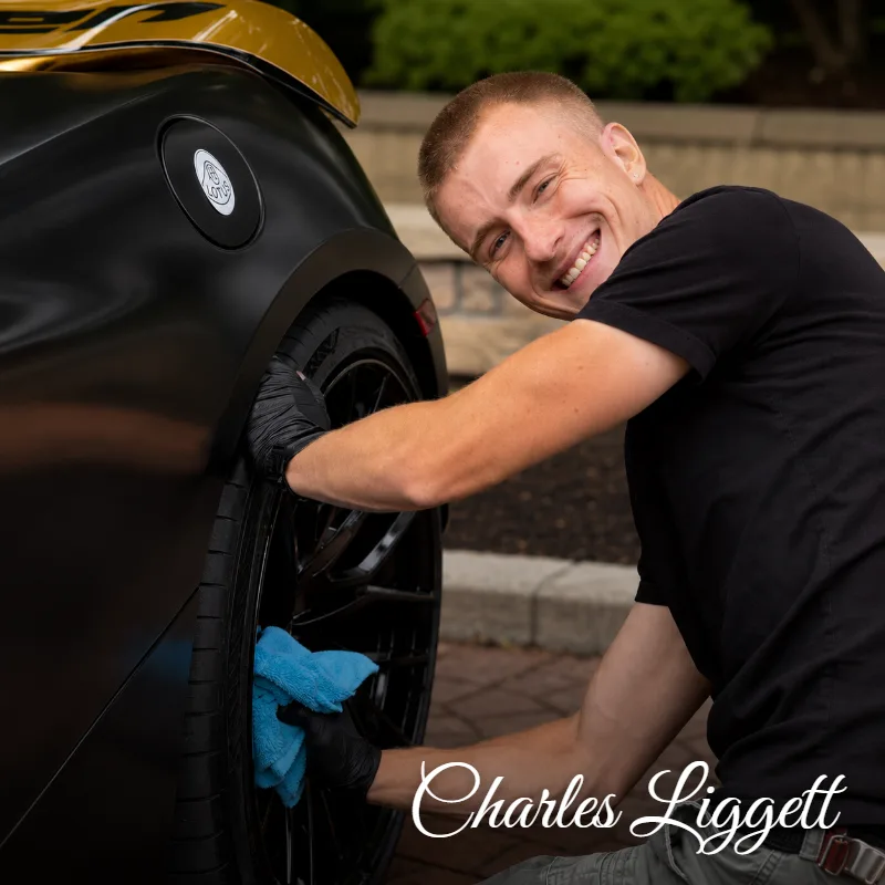 Charles Liggett of Liggett Mobile Detailing hand-detailing a wheel on a black sports car in Vancouver BC